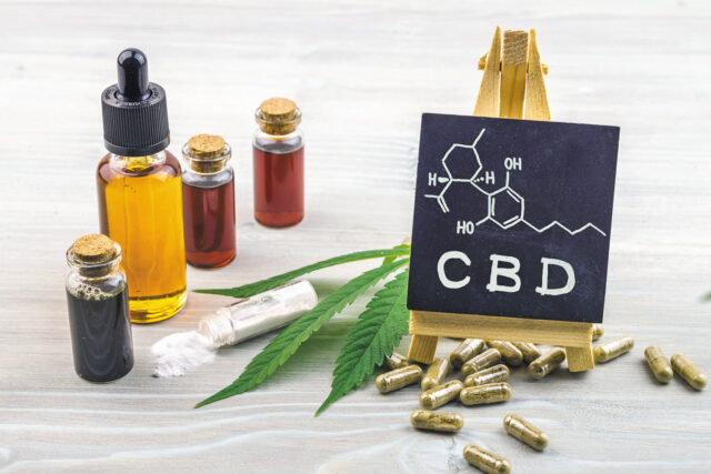 Full spectrum Cannabidiol CBD oils, capsules and crystals isolate with small blackboard with CBD word and chemical structure
