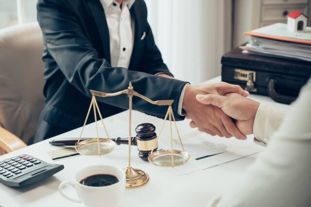 Businessman shaking hands to seal a deal with his partner lawyers or attorneys discussing a contract agreement