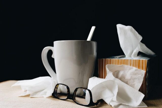 a shot of used tissues and barley tea in a mug depicting a person has a cold