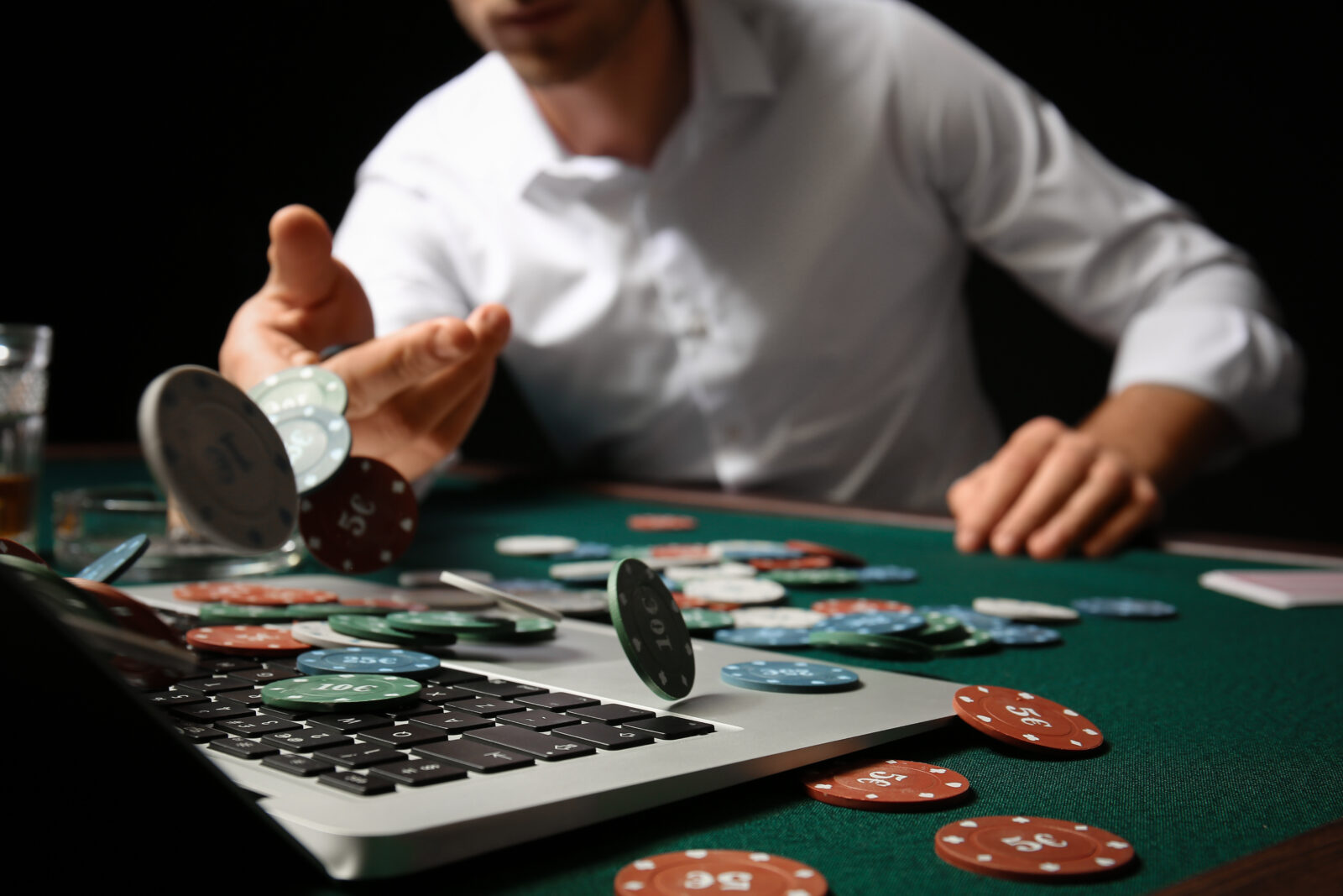 Young man playing poker online, closeup