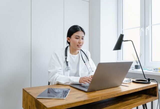 A doctor using her laptop in her office