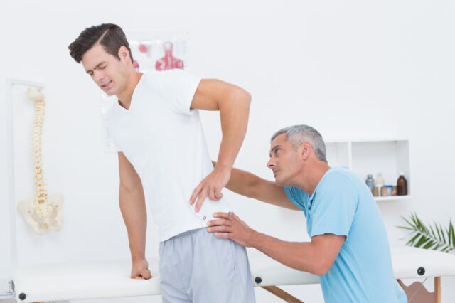 doctor examining his patient back in medical office