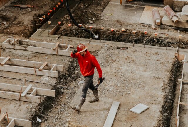 man-in-red-jacket-and-black-pants-walking-on-gray-concrete-stairs